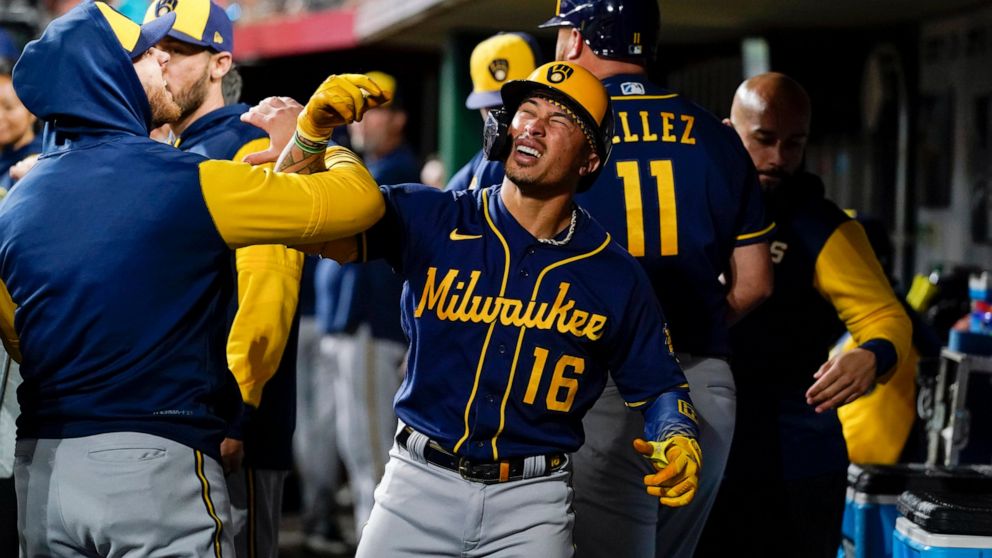 Milwaukee Brewers' Kolten Wong (16) celebrates with teammates in the dugout after his two-run home run during the sixth inning of the team's baseball game against the Cincinnati Reds on Thursday, Sept. 22, 2022, in Cincinnati. (AP Photo/Jeff Dean)