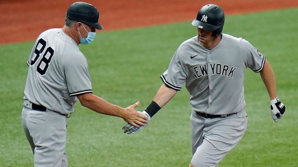 FILE- In this April 9, 2021, file photo, New York Yankees' DJ LeMahieu celebrates with third base coach Phil Nevin (88) after his home run off Tampa Bay Rays pitcher Hunter Strickland during the eighth inning of a baseball game in St. Petersburg, Fla