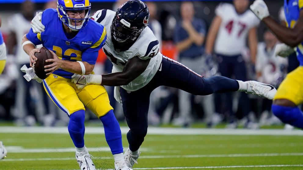 Los Angeles Rams quarterback John Wolford (13) is tackled by Houston Texans defensive end Demone Harris during the first half of a preseason NFL football game Friday, Aug. 19, 2022, in Inglewood, Calif. (AP Photo/Ashley Landis)