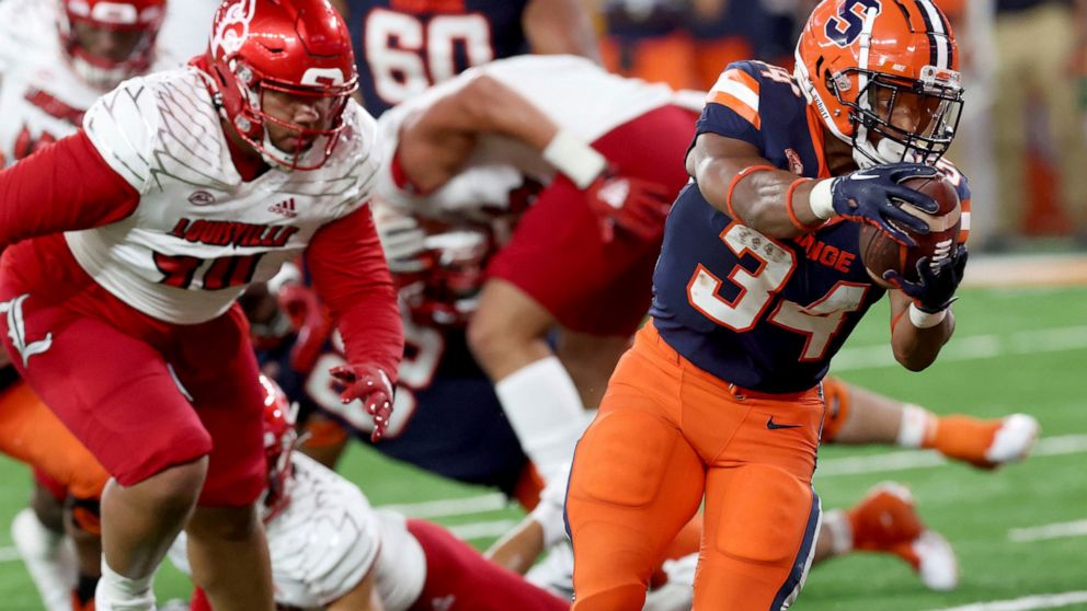 Syracuse running back Sean Tucker (34) reaches for the goal line during an NCAA college football game against Louisville in Syracuse, N.Y., Saturday, Sept 3, 2022. (Dennis Nett/The Post-Standard via AP)
