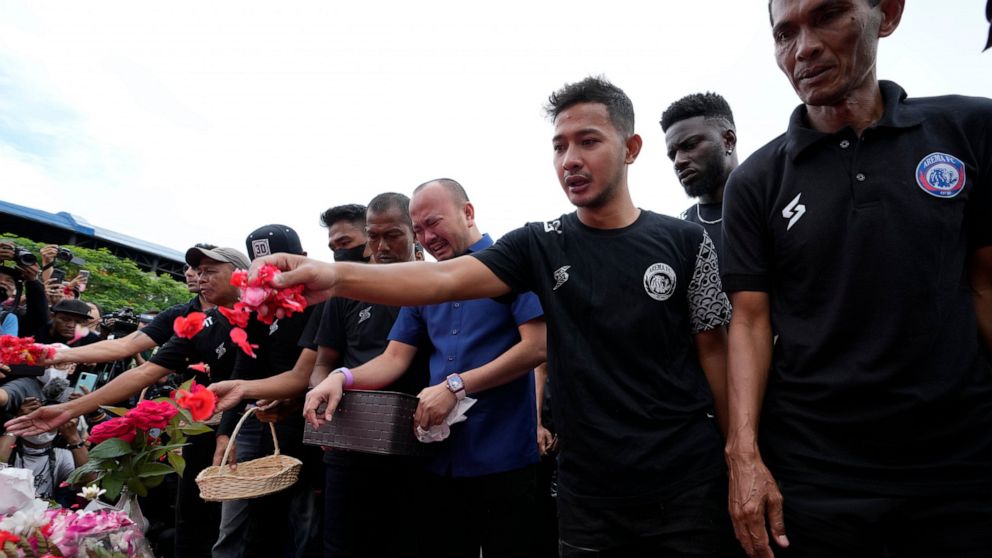 Players and officials of the soccer club Arema FC pray outside the Kanjuruhan Stadium where many fans lost their lives in a stampede Saturday night in Malang, Indonesia, Monday, Oct. 3, 2022. Police firing tear gas at Saturday night's match between h