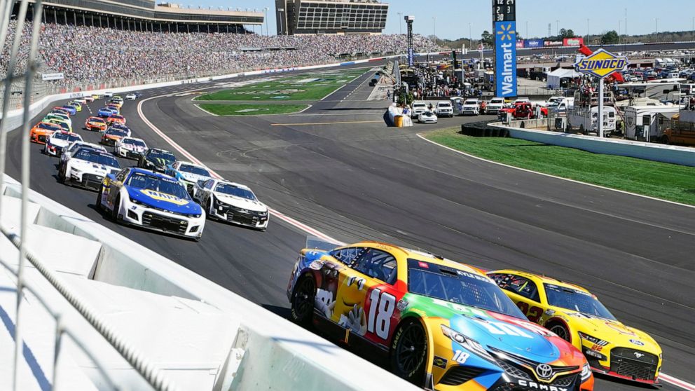 NASCAR Cup Series driver Kyle Busch (18) battels Joey Logano (22) as they go into Turn One during the NASCAR Cup Series auto race at Atlanta Motor Speedway in Hampton, Ga., Sunday, March 20, 2022. (AP Photo/John Bazemore)