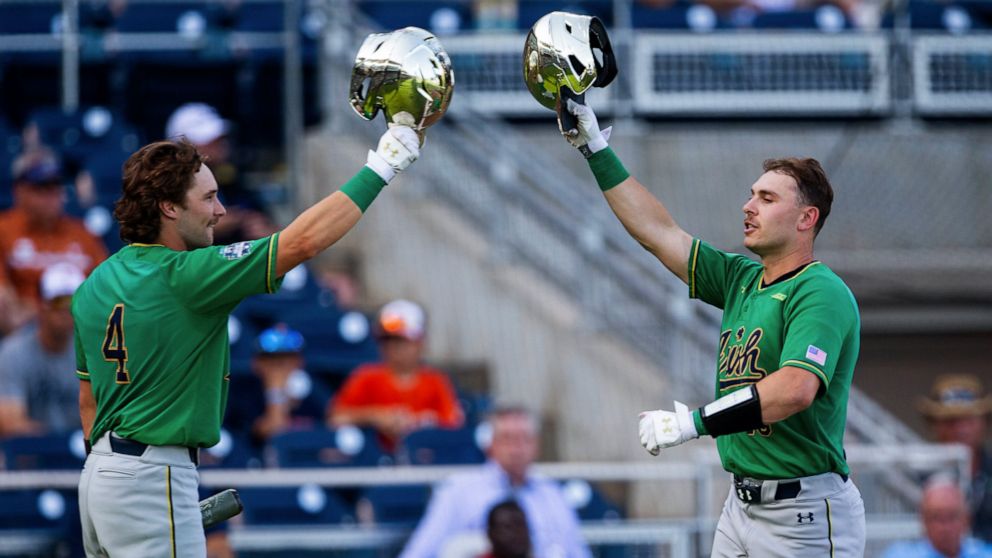 Notre Dame's Jared Miller (16) celebrates his home run against Texas with Carter Putz (4) during the first inning of an NCAA College World Series baseball game Friday, June 17, 2022, in Omaha, Neb. (AP Photo/John Peterson)