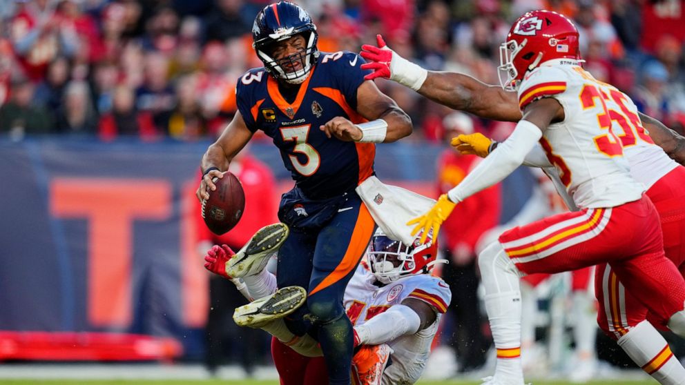 Denver Broncos quarterback Russell Wilson is sacked by Kansas City Chiefs linebacker Darius Harris, bottom, during the second half of an NFL football game Sunday, Dec. 11, 2022, in Denver. (AP Photo/Jack Dempsey)