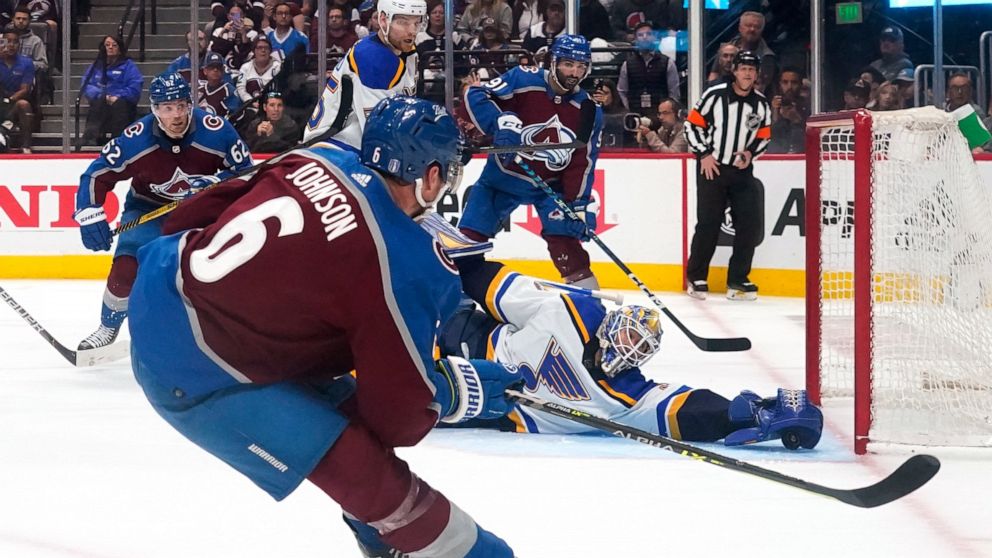 St. Louis Blues goaltender Jordan Binnington (50) makes a save against Colorado Avalanche defenseman Erik Johnson (6) during the second period in Game 1 of an NHL hockey Stanley Cup second-round playoff series Tuesday, May 17, 2022, in Denver. (AP Ph