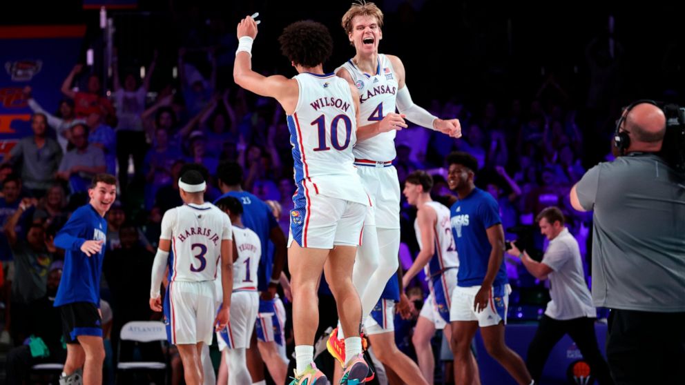 In a photo provided by Bahamas Visual Services, Kansas' Jalen Wilson (10) and Gradey Dick (4) celebrate during an NCAA college basketball game against Wisonsin in the Battle 4 Atlantis at Paradise Island, Bahamas, Thursday, Nov. 24, 2022. (Tim Aylen/