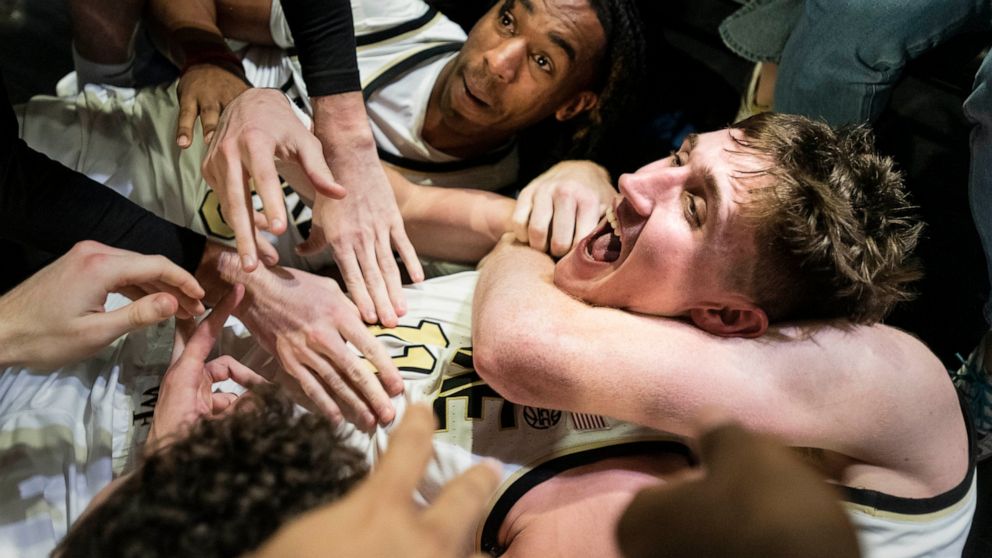 Wake Forest forward Andrew Carr, center, is hugged by teammates Lucas Taylor, left, and Cameron Hildreth (2) after Carr scored the game winning shot at the buzzer in the second half of an NCAA college basketball game against Appalachian State on Wedn
