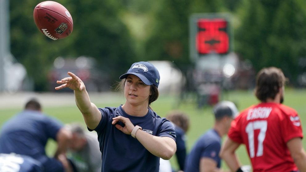 Amanda Ruller, who is currently working as an assistant running backs coach for the NFL football Seattle Seahawks through the league's Bill Walsh Diversity Fellowship program, passes a football during NFL football practice on June 8, 2022, in Renton,