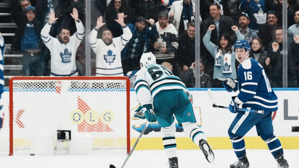 Toronto Maple Leafs' Mitchell Marner, right, turns to celebrate after scoring an empty-net goal against the San Jose Sharks during the third period of an NHL hockey game Wednesday, Nov. 30, 2022, in Toronto. (Chris Young/The Canadian Press via AP)