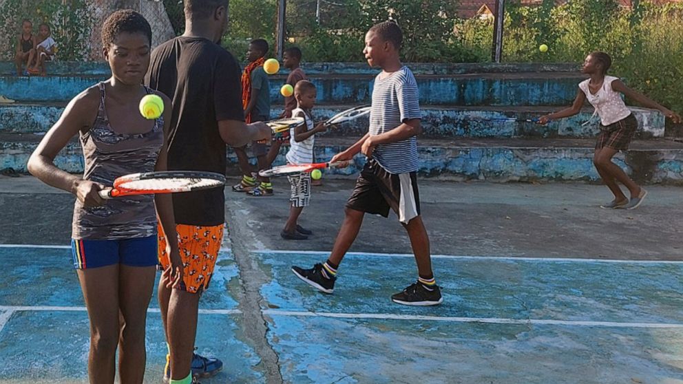 In this photo provided by Sam Jalloh, children in Sierra Leone participate in a tennis lesson in October 2021. Jalloh zig-zagged across West Africa in 2021 coaching tennis to kids. He took with him rackets, balls and a cellphone loaded with photos an