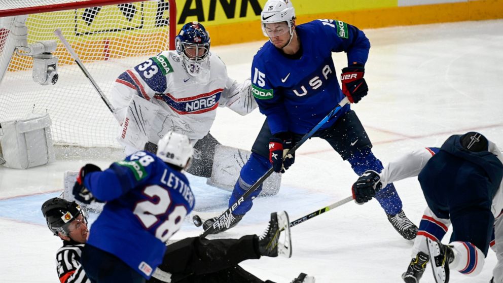 John Hayden, of the United States of America second right, watches as teammate Vinni Lettieri, foreground shoots to score past goalkeeper Henrik Haukeland of Norway, during the group B Hockey World Championship match between Norway and The United Sta