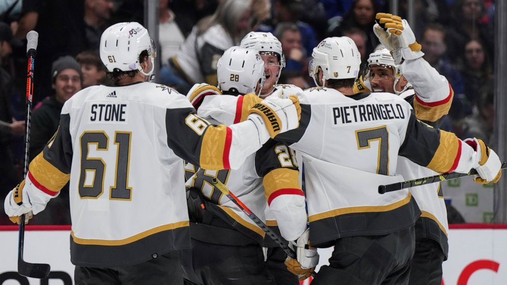 Vegas Golden Knights' Mark Stone, from left to right, William Carrier, Jack Eichel, Alex Pietrangelo and Alec Martinez celebrate Carrier's goal against the Vancouver Canucks during the second period of an NHL hockey game in Vancouver, British Columbi