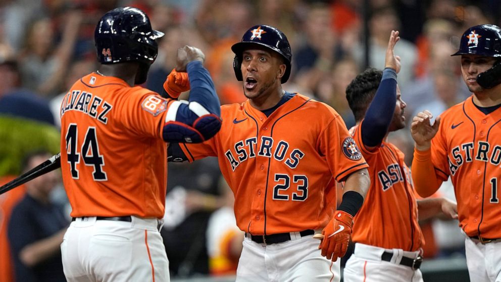 Houston Astros' Michael Brantley (23) celebrates with Yordan Alvarez (44) after hitting a grand slam against the Chicago White Sox during the sixth inning of a baseball game Friday, June 17, 2022, in Houston. (AP Photo/David J. Phillip)