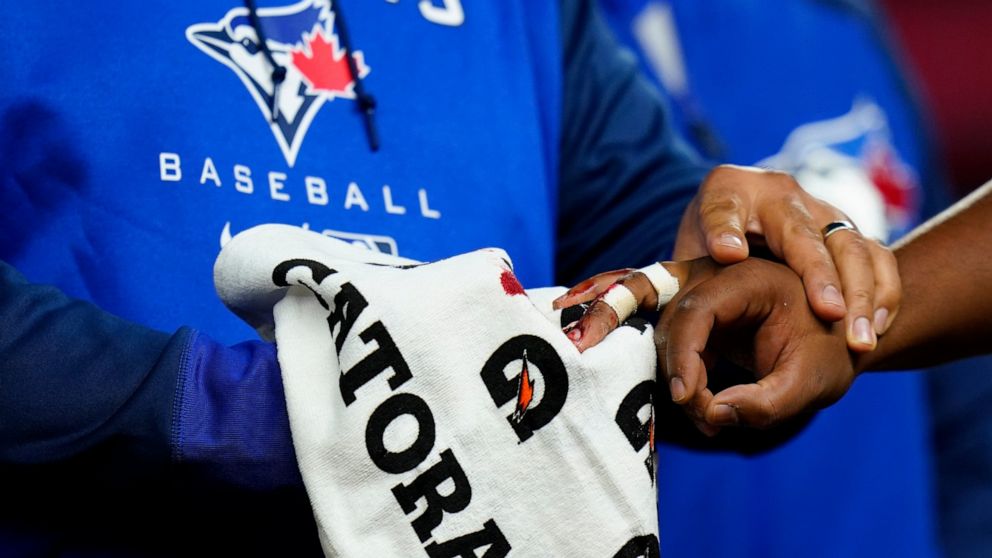 A trainer helps Toronto Blue Jays first baseman Vladimir Guerrero Jr., right, who suffered an injury during the second inning of the team's baseball game against the New York Yankees on Wednesday, April 13, 2022, in New York. (AP Photo/Frank Franklin II)