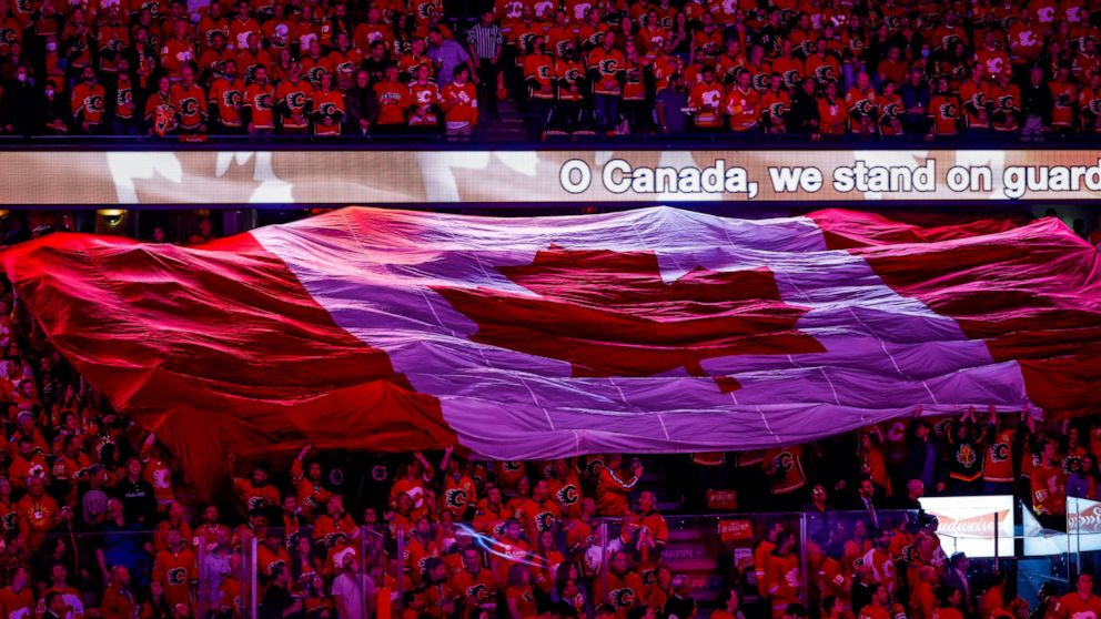 Calgary Flames fans sing the Canadian national anthem before Game 1 of the team's NHL hockey first-round playoff series against the Dallas Stars on Tuesday, May 3, 2022, in Calgary, Alberta. (Jeff McIntosh/The Canadian Press via AP)
