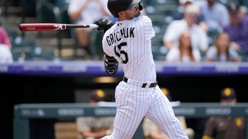 Colorado Rockies' Randal Grichuk follows through with his swing after connecting for a double to drive in two runs off San Diego Padres starting pitcher Blake Snell in the second inning of a baseball game Thursday, July 14, 2022, in Denver. (AP Photo