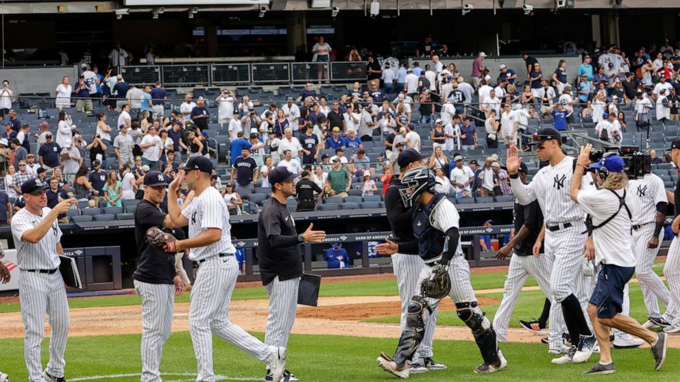 New York Yankees players celebrate after their win in a baseball game against the Toronto Blue Jays, Sunday, Aug. 21, 2022, in New York. (AP Photo/Corey Sipkin)