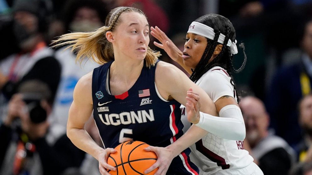 UConn's Paige Bueckers tries to get past South Carolina's Destanni Henderson during the first half of a college basketball game in the final round of the Women's Final Four NCAA tournament Sunday, April 3, 2022, in Minneapolis. (AP Photo/Charlie Neib