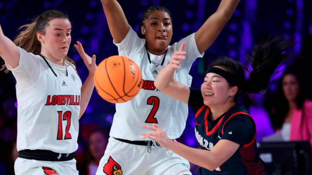 In a photo provided by Bahamas Visual Services, Gonzaga guard Kayleigh Truong, right, is defended by Louisville guard Payton Verhulst, left, and forward Nyla Harris during an NCAA college basketball game in the Battle 4 Atlantis at Paradise Island, B