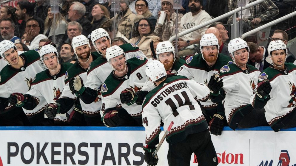 Arizona Coyotes defenseman Shayne Gostisbehere (14) celebrates with teammates after scoring the winning powerplay goal against the Toronto Maple Leafs during third-period NHL hockey game action in Toronto, Monday, Oct. 17, 2022. (Alex Lupul/The Canad