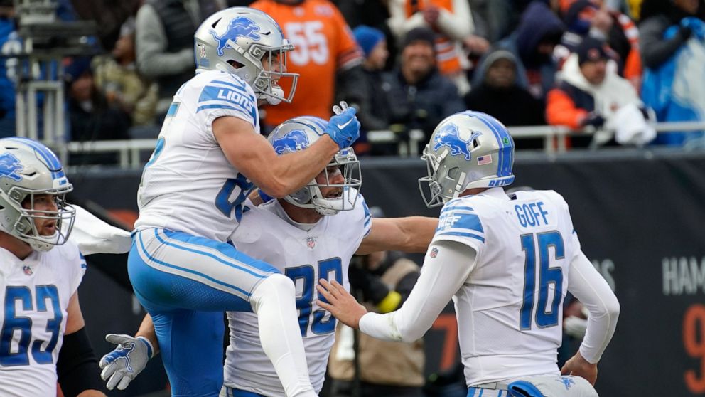 Detroit Lions tight end Brock Wright (89) celebrates his two-yard touchdown reception with quarterback Jared Goff (16) and Tom Kennedy (85) during the first half of an NFL football game against the Chicago Bears in Chicago, Sunday, Nov. 13, 2022. (AP