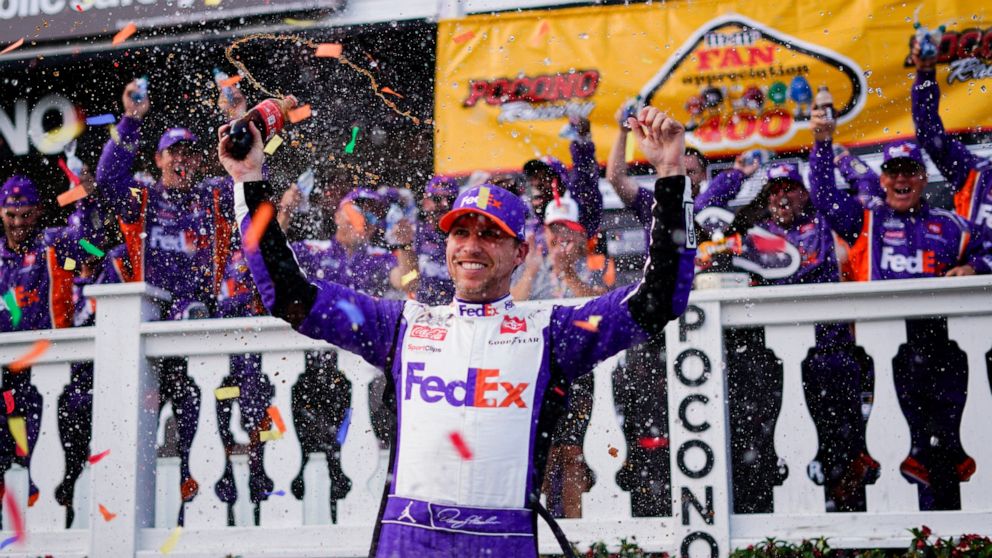 Denny Hamlin (11) celebrates after winning the NASCAR Cup Series auto race at Pocono Raceway, Sunday, July 24, 2022, in Long Pond, Pa. (AP Photo/Matt Slocum)