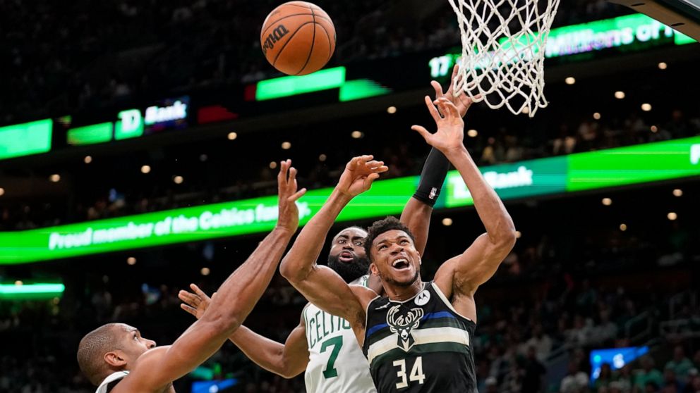 Boston Celtics center Al Horford, left, and guard Jaylen Brown, center, vie for a rebound with Milwaukee Bucks forward Giannis Antetokounmpo, right, during the first half of Game 7 of an NBA basketball Eastern Conference semifinals playoff series, Su