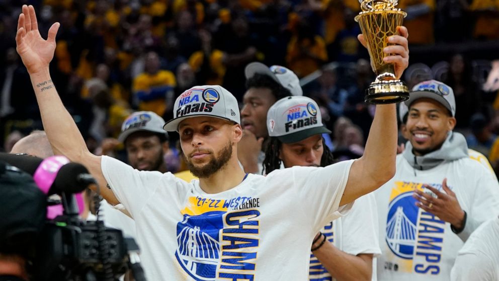 Golden State Warriors' Stephen Curry holds up the conference finals MVP trophy after the Warriors defeated the Dallas Mavericks in Game 5 of the NBA basketball playoffs Western Conference finals in San Francisco, Thursday, May 26, 2022. (AP Photo/Jef