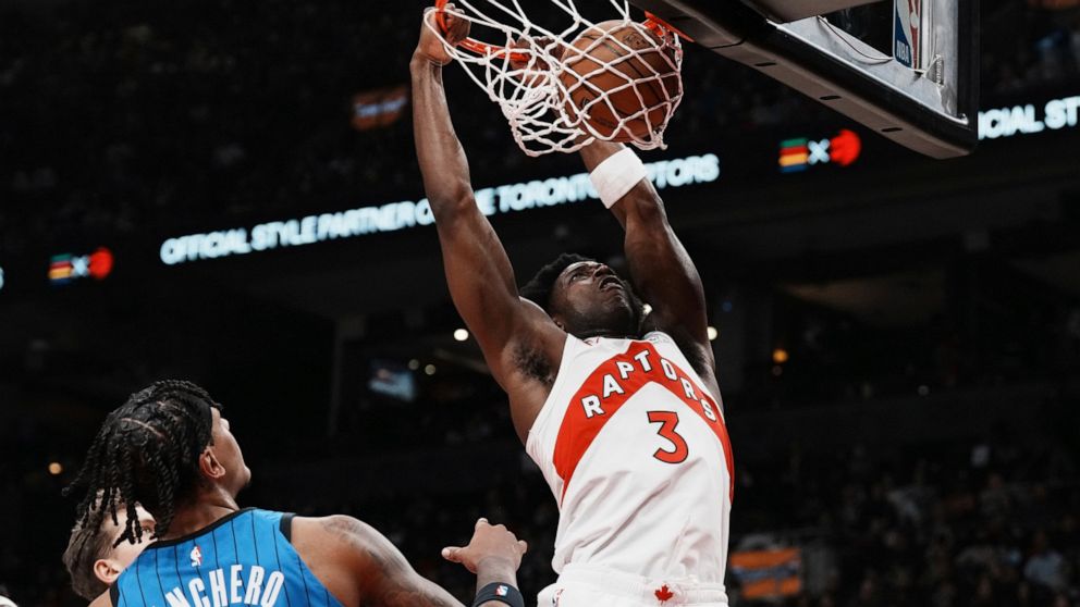 Toronto Raptors' O.G. Anunoby dunks on Orlando Magic's Paolo Banchero during the first half of an NBA basketball game, Saturday, Dec. 3, 2022 in Toronto. (Chris Young/The Canadian Press via AP)