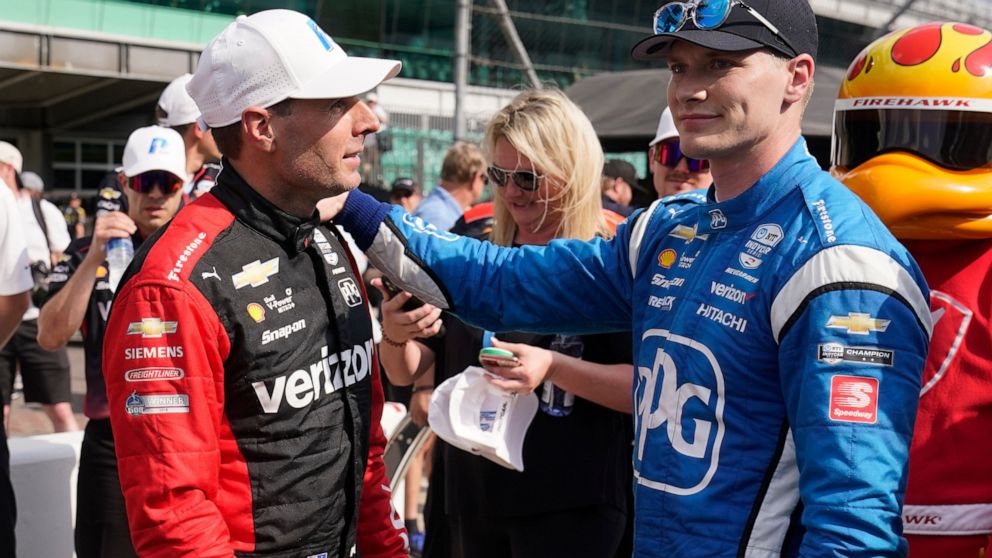 Will Power, left, of Australia, is congratulated by Josef Newgarden after Power won the pole for the IndyCar auto race at Indianapolis Motor Speedway, Friday, May 13, 2022, in Indianapolis. (AP Photo/Darron Cummings)