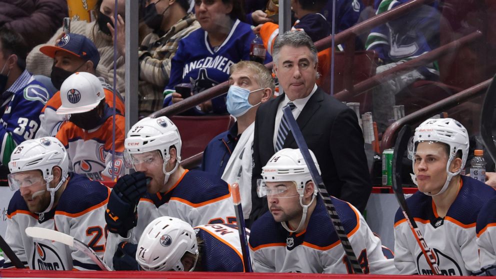 Edmonton Oilers head coach Dave Tippett, back, stands on the bench behind Leon Draisaitl, of Germany, from left to right, Warren Foegele, Ryan McLeod, Devin Shore and Jesse Puljujarvi, of Sweden, during the third period of an NHL hockey game against 