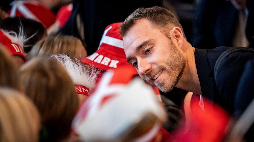 Denmark's Christian Eriksen signs autographs for elementary school children during an event to send the national soccer team off on their journey to the World Cup in Qatar, from the Vilhelm Lauritzen Terminal in Copenhagen, Denmark, Tuesday, Nov. 15,