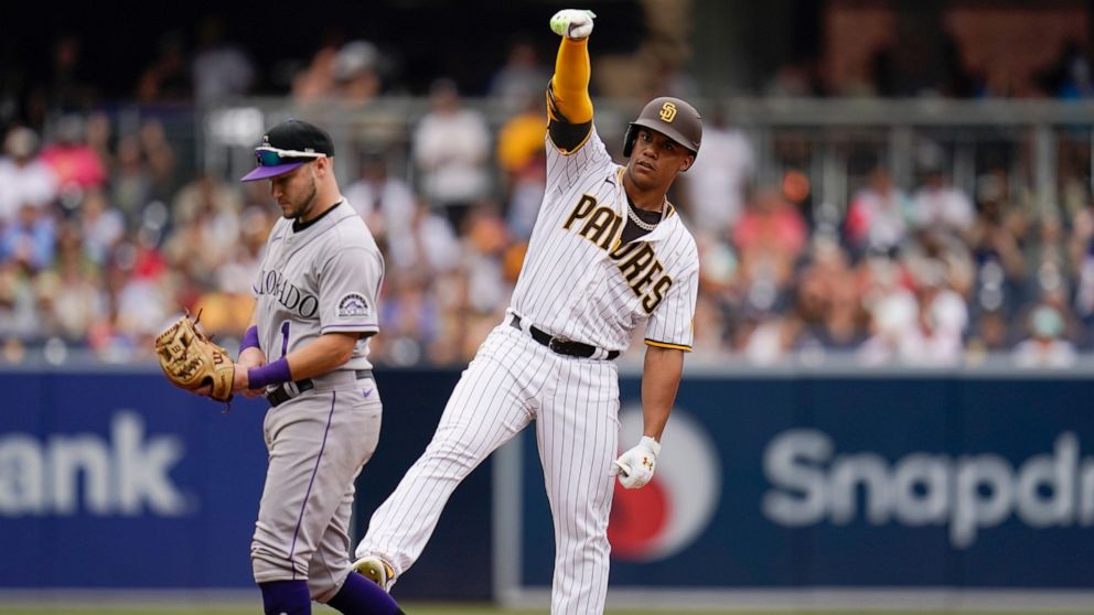 San Diego Padres' Juan Soto, right, reacts after hitting a double, next to Colorado Rockies shortstop Garrett Hampson during the seventh inning of a baseball game Thursday, Aug. 4, 2022, in San Diego. (AP Photo/Gregory Bull)