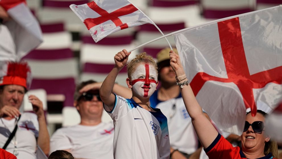 Fans wave England flags prior to the start of the World Cup group B soccer match between England and Iran at the Khalifa International Stadium in Doha, Qatar, Monday, Nov. 21, 2022. (AP Photo/Abbie Parr)