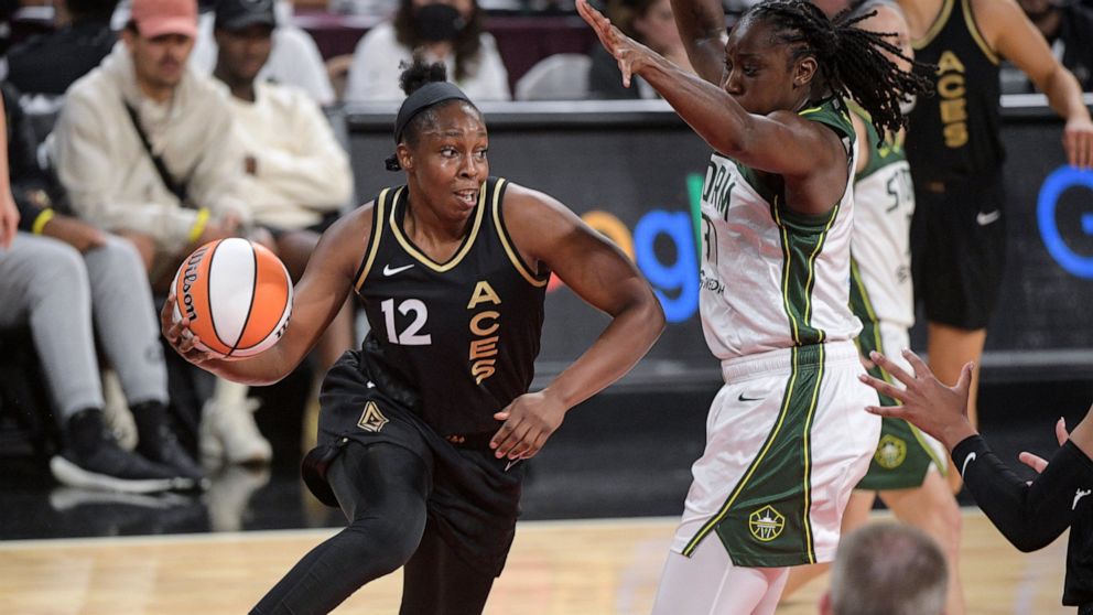 Las Vegas Aces guard Chelsea Gray (12) passes around Seattle Storm's Tina Charles during the first half of a WNBA basketball game Sunday, Aug. 14, 2022, in Las Vegas. (AP Photo/Sam Morris)