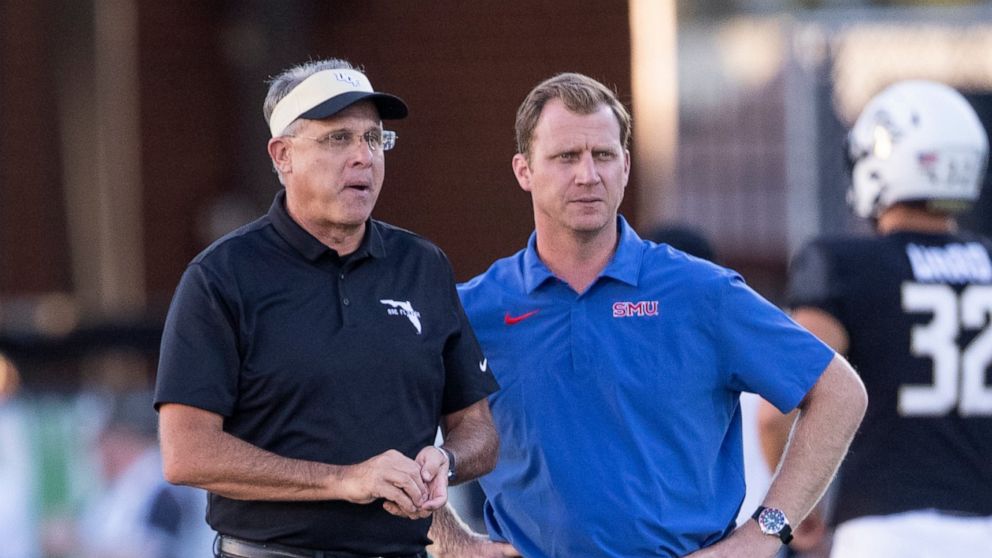 Central Florida coach Gus Malzahn, left, and SMU coach Rhett Lashlee talk before an NCAA college football game Wednesday, Oct. 5, 2022, in Orlando, Fla. (Willie J. Allen Jr./Orlando Sentinel via AP)
