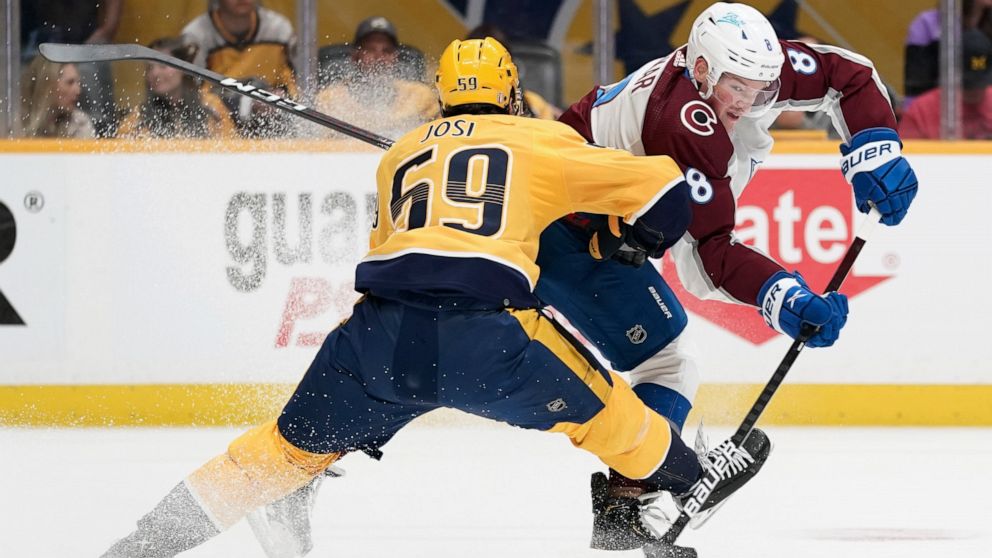 Colorado Avalanche defenseman Cale Makar (8) passes the puck past Nashville Predators' Roman Josi (59) during the first period in Game 4 of an NHL hockey first-round playoff series Monday, May 9, 2022, in Nashville, Tenn. (AP Photo/Mark Humphrey)