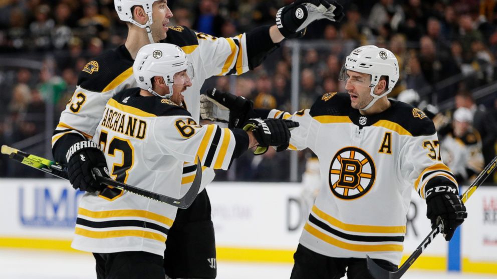Boston Bruins left wing Brad Marchand (63) celebrates with teammates Zdenoa Chara, back left, and Patrice Bergeron after scoring against the Vegas Golden Knights during the third period of an NHL hockey game Wednesday, Feb. 20, 2019, in Las Vegas. (A