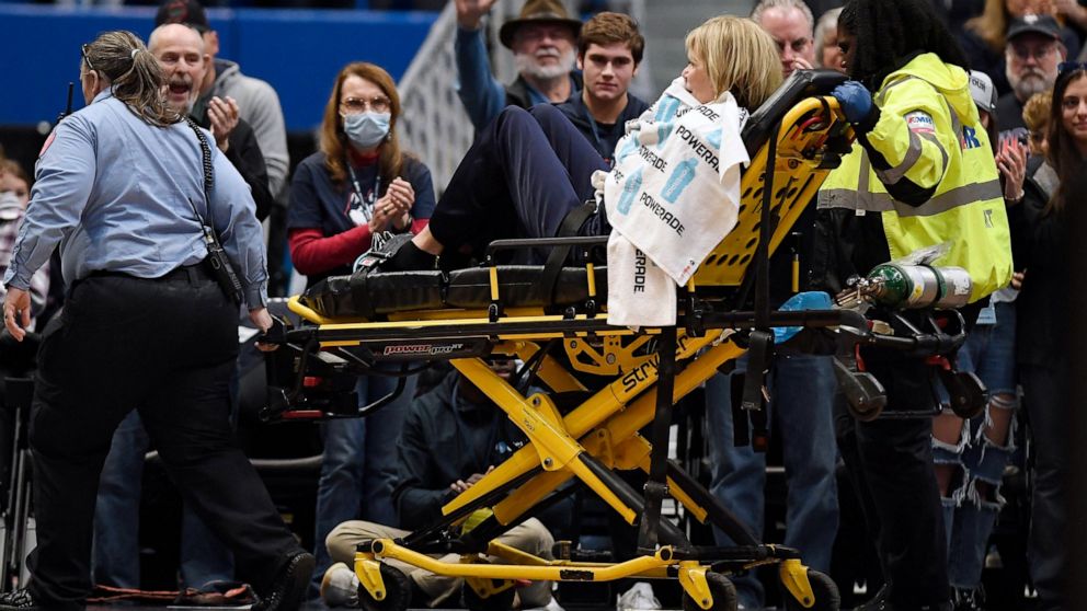 Associate Head Coach Chris Dailey is taken off the basketball court on a stretcher before an NCAA basketball game against North Carolina State, Sunday, Nov. 20, 2022, in Hartford, Conn. Dailey experienced a medical emergency during the national anthe
