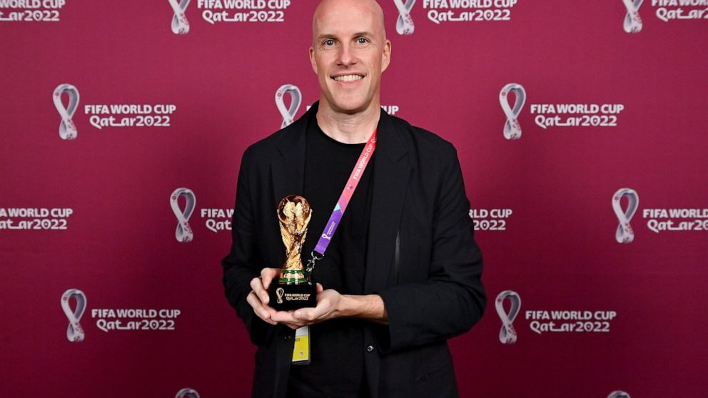 Grant Wahl smiles as he holds a World Cup replica trophy during an award ceremony in Doha, Qatar on Nov. 29, 2022. Wahl, one of the most well-known soccer writers in the United States, died early Saturday Dec. 10, 2022 while covering the World Cup ma