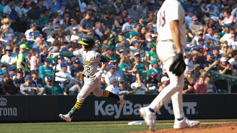 Oakland Athletics' Nick Allen, left, rounds third after hitting a two-run home run as Seattle Mariners starting pitcher Robbie Ray, right, walks to the mound during the sixth inning of a baseball game, Sunday, Oct. 2, 2022, in Seattle. (AP Photo/Jaso