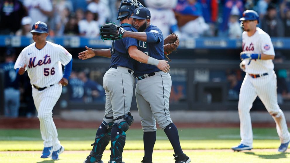 Seattle Mariners catcher Cal Raleigh and relief pitcher Diego Castillo celebrate after defeating the New York Mets 8-7 during a baseball game, Sunday, May 15, 2022, in New York. (AP Photo/Noah K. Murray)