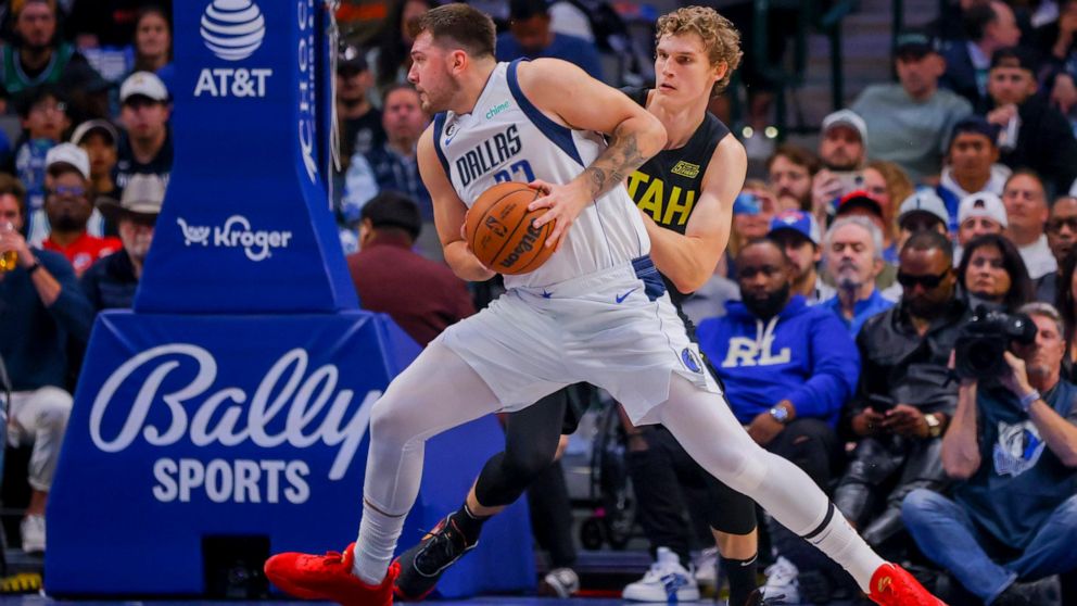 Dallas Mavericks point guard Luka Doncic. (77) looks to the hoop as Utah Jazz forward Lauri Markkanen, right, defends during the first half of an NBA basketball game, Wednesday, Nov. 2, 2022, in Dallas. (AP Photo/Gareth Patterson)