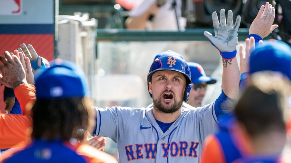 New York Mets designated hitter J.D. Davis, center, reacts as he is congratulated in the dugout after hitting a solo home run against the Los Angeles Angels during the fourth inning of a baseball game in Anaheim, Calif., Sunday, June 12, 2022. (AP Ph