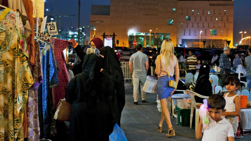 FILE - A foreign woman wearing a short dress walks at Souq Waqif in Doha, Qatar, Monday, June 2, 2014. Qatar has sought to portray itself as welcoming foreigners to this hereditarily ruled emirate, where traditional Muslim values remain strong.(AP Ph