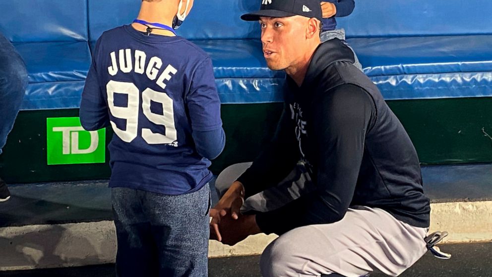 Nine-year-old Derek Rodriguez meets New York Yankees' Aaron Judge in the dugout Wednesday, May 4, 2022, before the Yankees' baseball game against the Toronto Blue Jays in Toronto. The young Yankees fan who became a viral sensation this week shed more