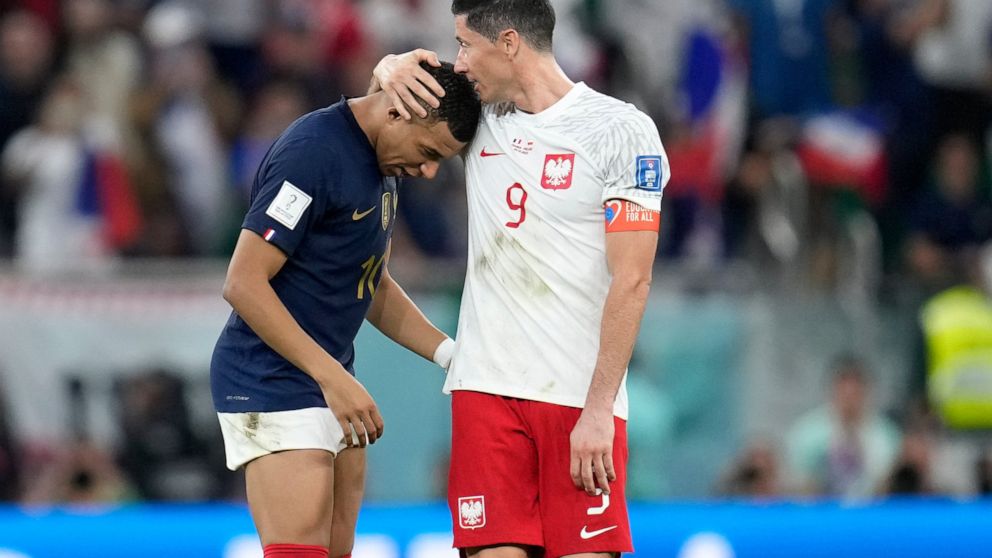 France's Kylian Mbappe, left, and Poland's Robert Lewandowski, right, speak after the World Cup round of 16 soccer match between France and Poland, at the Al Thumama Stadium in Doha, Qatar, Sunday, Dec. 4, 2022. (AP Photo/Natacha Pisarenko)