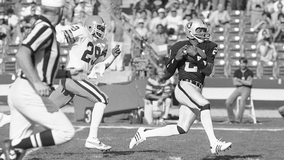 FILE - Los Angeles Raiders wide receiver Cliff Branch, right, catches a pass from quarterback Jim Plunkett for a 64-yard gain as Cleveland Browns' Hanford Dixon defends during the first quarter of an NFL football playoff game in Los Angeles, on Jan. 