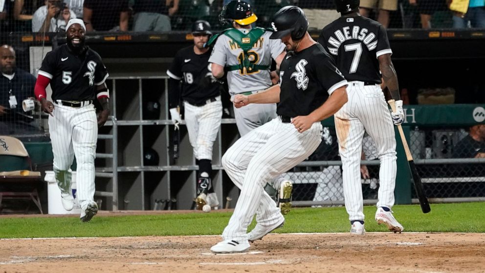 Chicago White Sox's Adam Engel scores on a wild pitch from Oakland Athletics relief pitcher Zach Jackson to give the White Sox a 3-2 win during during the ninth inning of a baseball game Saturday, July 30, 2022, in Chicago. (AP Photo/Charles Rex Arbogast)