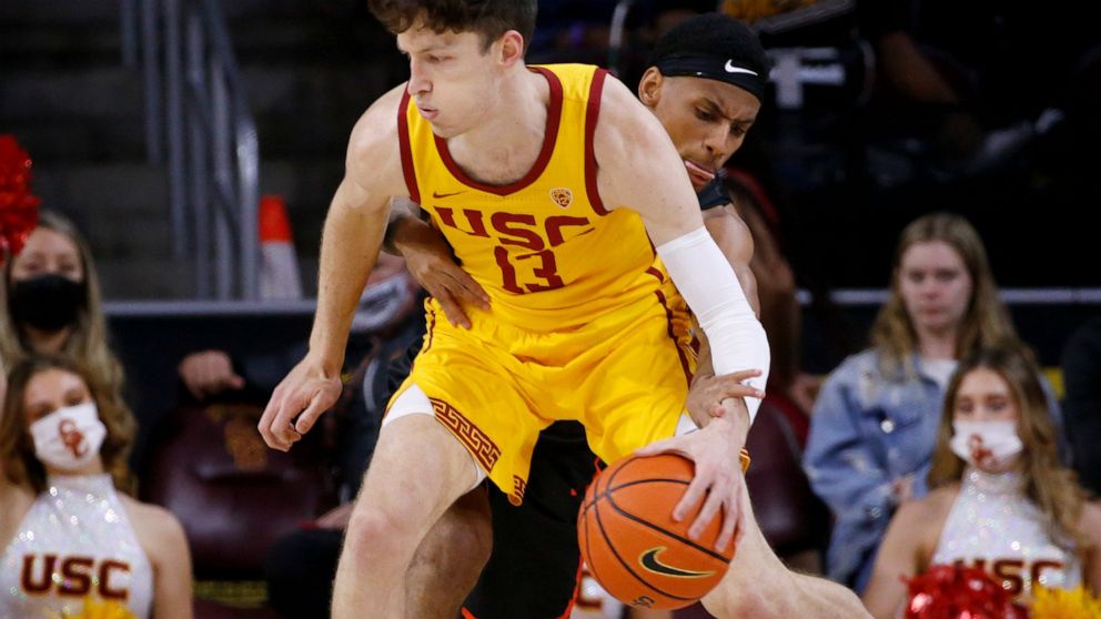 Pacific guard Jaden Byers, back, tries to steal the ball away from Southern California guard Drew Peterson (13) during the first half of an NCAA college basketball game Tuesday, Feb. 8, 2022, in Los Angeles. (AP Photo/Ringo H.W. Chiu)